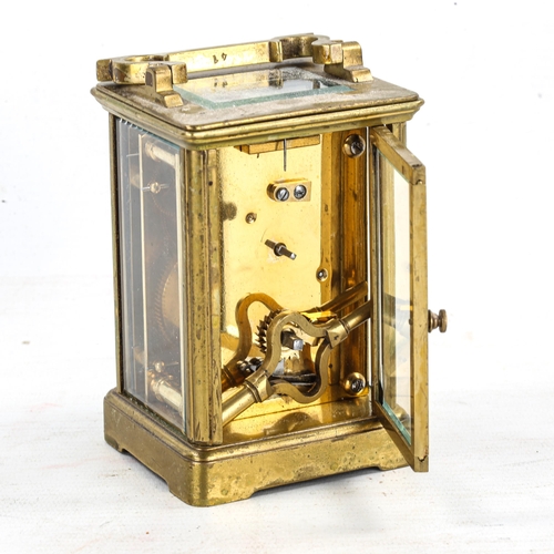 83 - A brass-cased carriage clock, white enamel dial with Roman numeral hour markers, and glass exhibitio... 