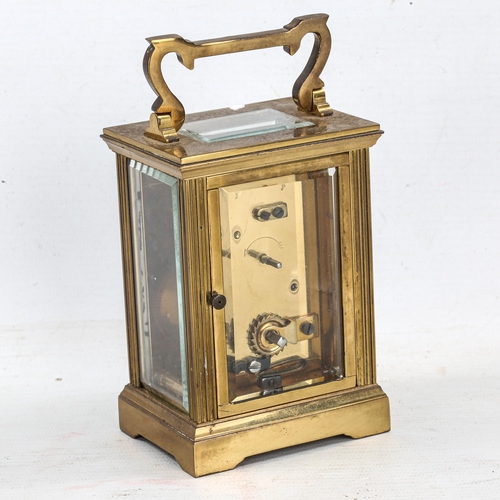 85 - A brass cased carriage clock, white enamel dial with Roman numerals and bevelled glass exhibition pl... 