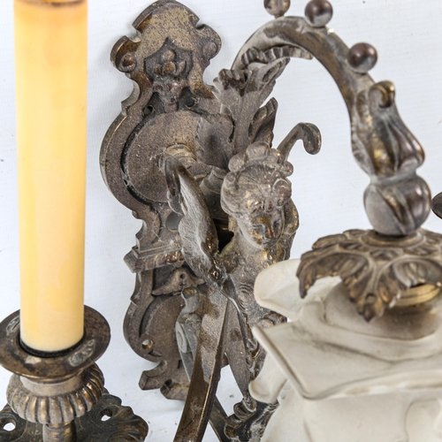 1463 - A pair of ornate bronze twin-branch wall light fittings, decorated with winged figures and frilled g... 