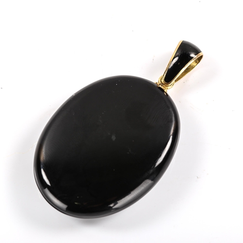 337 - A Victorian onyx paste and black enamel mourning pendant locket, unmarked yellow metal settings, pen... 