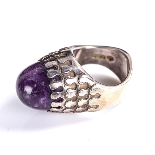 511 - A late 20th century silver and amethyst abstract ring, set with high cabochon amethyst, by Jack Spen... 