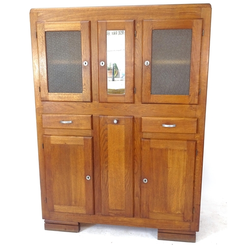 2080 - A 1930s French oak kitchen cabinet, with glazed and panelled cupboards, 2 frieze drawers and central... 