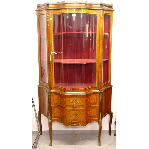 2606 - A Continental walnut and kingwood vitrine display cabinet of serpentine form, pierced brass gallery,... 