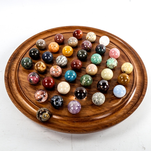 179 - A set of agate and hardstone marbles on turned wood solitaire board, diameter 36cm, marbles diameter... 