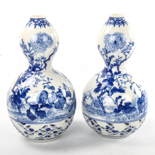 77 - A pair of Japanese blue and white porcelain double-gourd vases, with hand painted decoration and ret... 