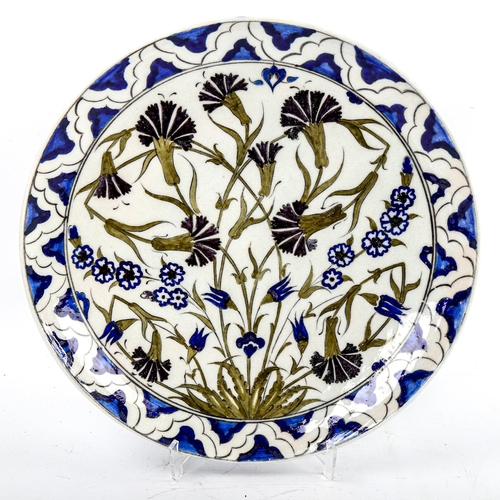 83 - A Turkish pottery plate, with hand painted designs, diameter 33cm