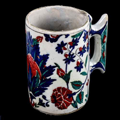 86 - A Turkish pottery pint mug, with painted enamel decoration, height 13cm