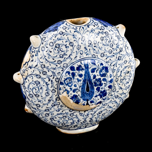 89 - A Turkish pottery moon-shaped water flask, with painted blue and white decoration, height 19cm