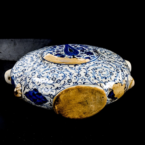 89 - A Turkish pottery moon-shaped water flask, with painted blue and white decoration, height 19cm