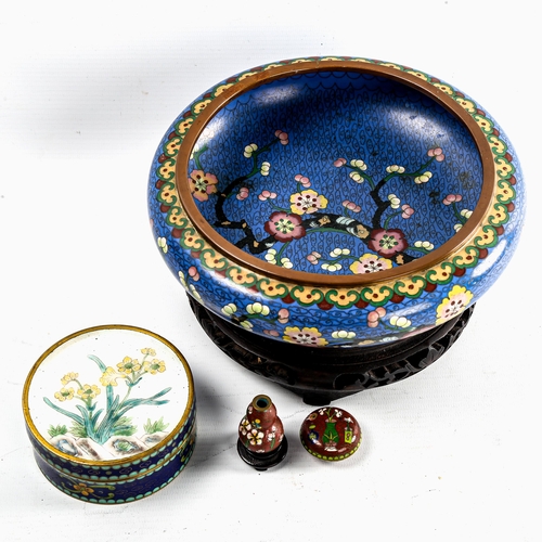 97 - A Japanese blue ground cloisonne enamel bowl, with prunus tree decoration, diameter 20cm, on wood st... 