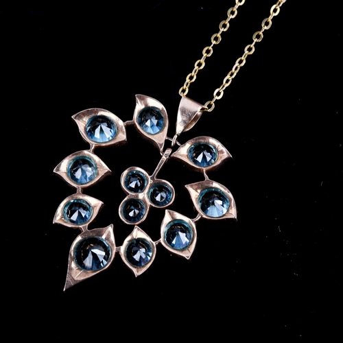 517 - A Middle Eastern blue zircon floral pendant necklace, unmarked yellow metal settings with round cut ... 