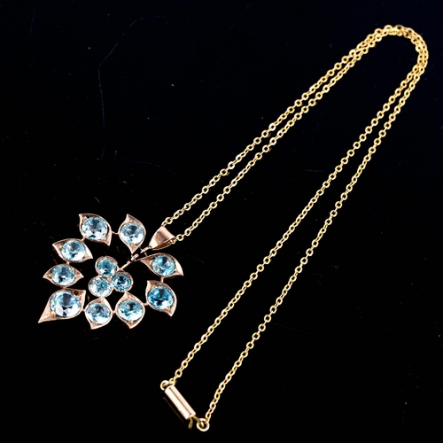 517 - A Middle Eastern blue zircon floral pendant necklace, unmarked yellow metal settings with round cut ... 