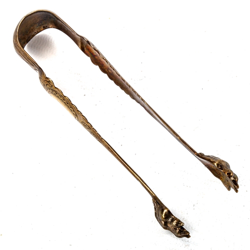 527 - A pair of 19th century French silver-gilt lion paw sugar tongs, bright-cut engraved ribbon bow decor... 