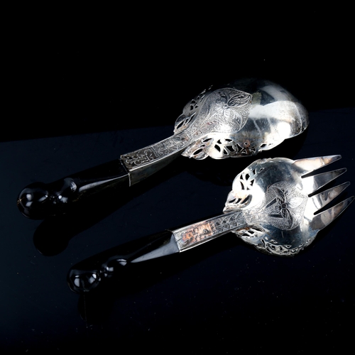 531 - A pair of Middle Eastern unmarked silver horn-handled salad servers, pierced and engraved floral dec... 