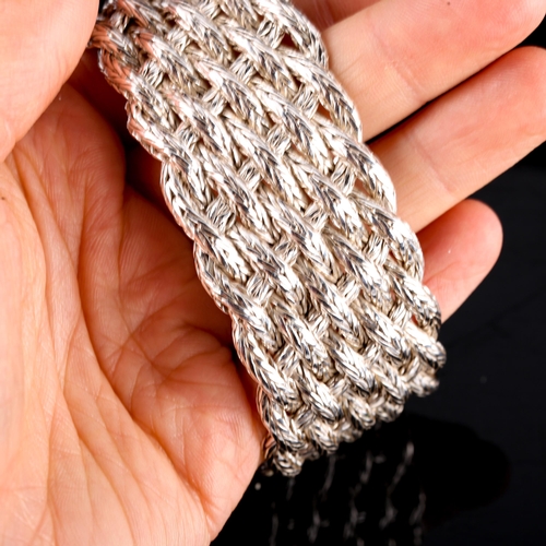 538 - A large modern silver basketweave bracelet, with relief embossed floral buckle, bracelet width 30.2m... 