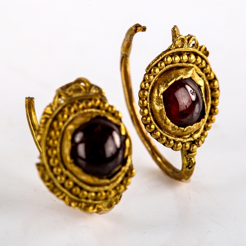 539 - A pair of Roman unmarked gold cabochon garnet earrings, beaded and lobed circular medallions, allege... 