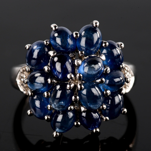 556 - A modern 9ct white gold sapphire and diamond cluster dress ring, set with oval cabochon sapphires an... 