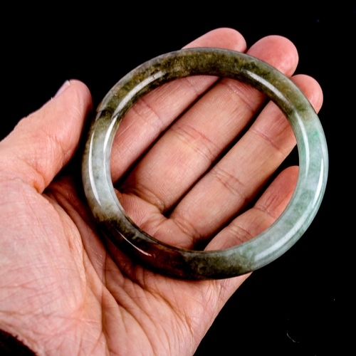 595 - A Chinese carved and polished jade slave bangle, overall diameter 7cm, 36.7g