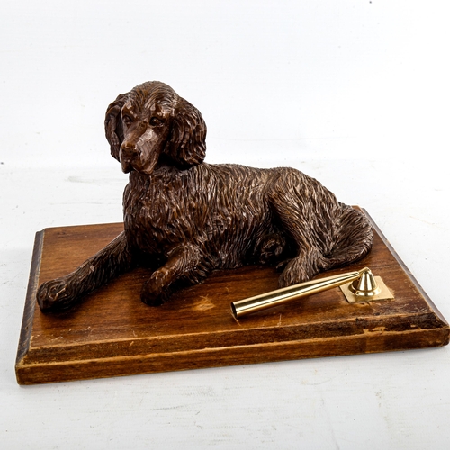 254 - A Black Forest type desk stand, surmounted by a reclining dog, width 25.5cm