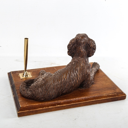 254 - A Black Forest type desk stand, surmounted by a reclining dog, width 25.5cm