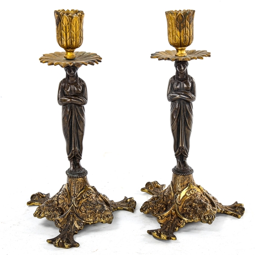 262 - A pair of patinated and gilded bronze candlesticks, supported by Classical figures, height 22cm