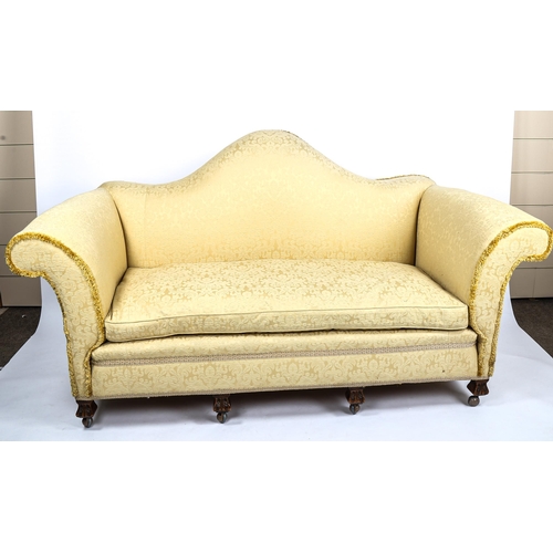 281 - An upholstered sofa, circa 1900, with serpentine-shaped back and rollover arms, on carved feet, over... 