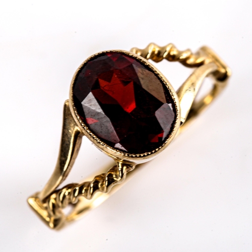 621 - A late 20th century unmarked gold garnet dress ring, set with oval mixed-cut garnet with rope twist ... 