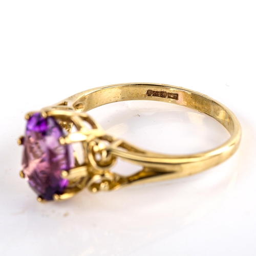 623 - A modern 9ct gold amethyst dress ring, set with oval mixed-cut amethyst and openwork shoulders, sett... 