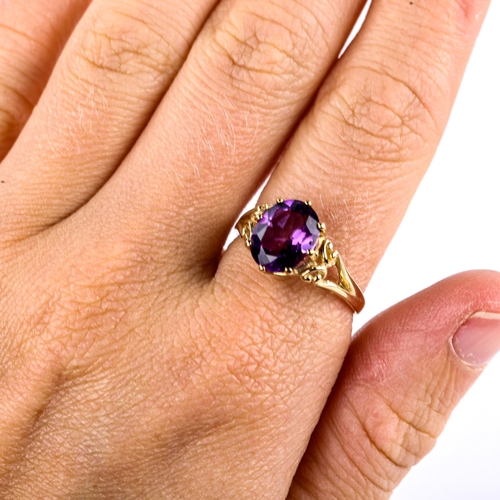 623 - A modern 9ct gold amethyst dress ring, set with oval mixed-cut amethyst and openwork shoulders, sett... 