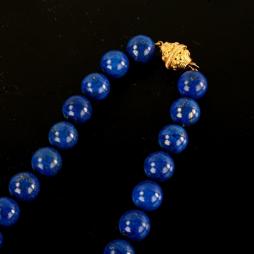 643 - A large single-row polished lapis lazuli bead necklace, with unmarked yellow metal clasp, bead diame... 