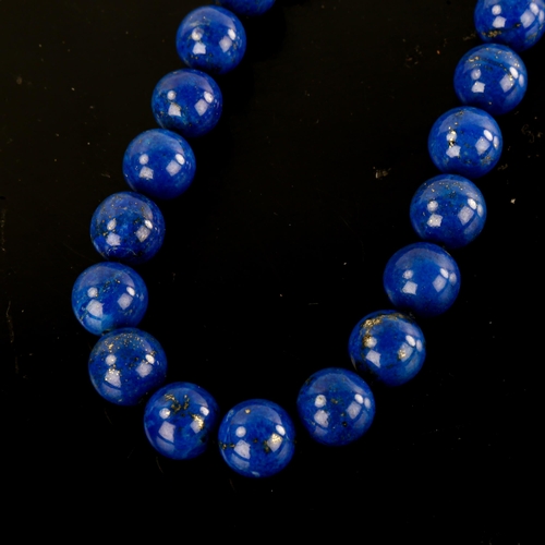 643 - A large single-row polished lapis lazuli bead necklace, with unmarked yellow metal clasp, bead diame... 