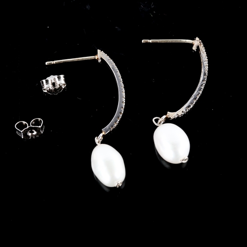 669 - A pair of modern unmarked white gold pearl and diamond half hoop stud earrings, earring height 34.5m... 