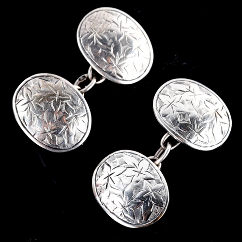 671 - A pair of early 20th century silver oval cufflinks, engraved floral decoration, by George Loveridge,... 