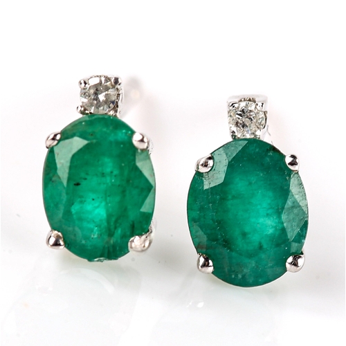 676 - A pair of modern 9ct white gold emerald and diamond stud earrings, set with oval mixed-cut emerald a... 