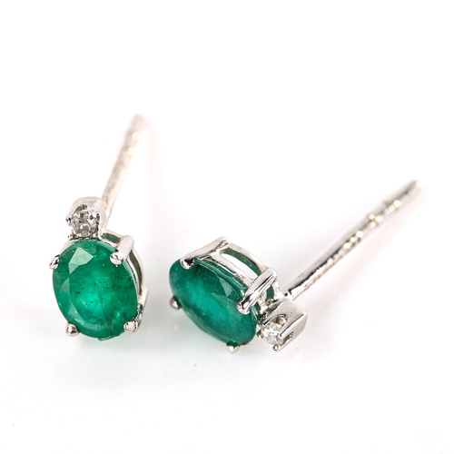 676 - A pair of modern 9ct white gold emerald and diamond stud earrings, set with oval mixed-cut emerald a... 