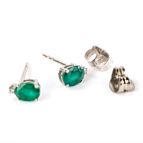 676 - A pair of modern 9ct white gold emerald and diamond stud earrings, set with oval mixed-cut emerald a... 