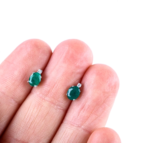 676 - A pair of modern 9ct white gold emerald and diamond stud earrings, set with oval mixed-cut emerald a... 