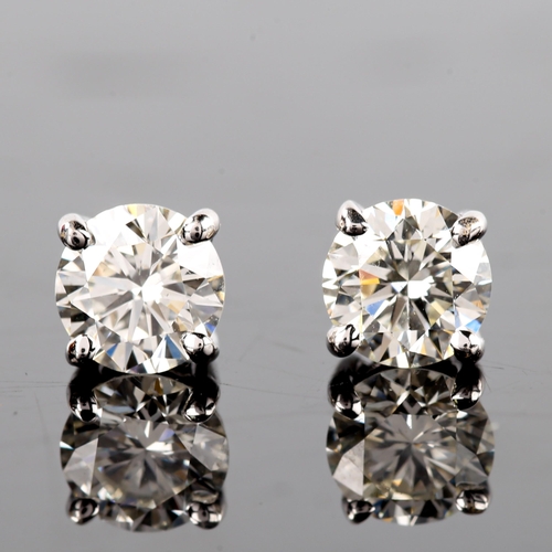 679 - A pair of modern 1.2ct solitaire diamond stud earrings, in 18ct white gold settings with modern roun... 