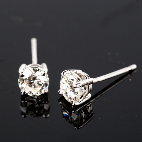 679 - A pair of modern 1.2ct solitaire diamond stud earrings, in 18ct white gold settings with modern roun... 