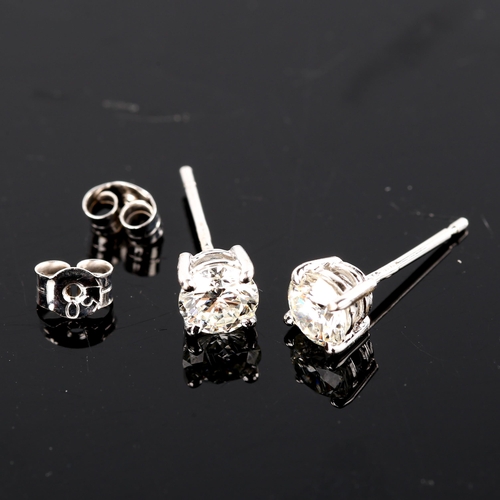 679 - A pair of modern 1.2ct solitaire diamond stud earrings, in 18ct white gold settings with modern roun... 