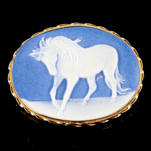 738 - A modern Wedgwood blue and white Jasperware style ceramic horse plaque brooch, in a 9ct gold rope tw... 