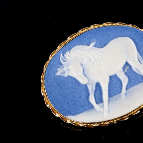 738 - A modern Wedgwood blue and white Jasperware style ceramic horse plaque brooch, in a 9ct gold rope tw... 