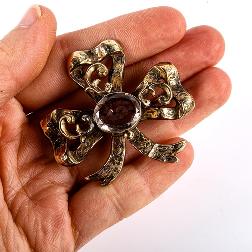 772 - A large Victorian smoky quartz ribbon bow brooch, unmarked yellow metal settings with foliate engrav... 