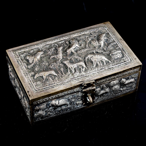 776 - A 19th century Indian silver Paan Daan betel nut box, relief embossed and engraved village scenes wi... 