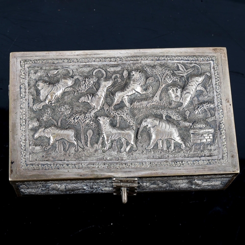 776 - A 19th century Indian silver Paan Daan betel nut box, relief embossed and engraved village scenes wi... 