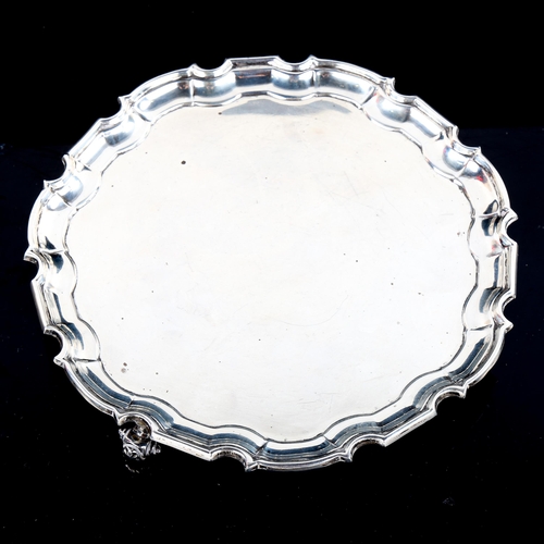 777 - A George VI circular silver salver, scalloped rim with scrolled acanthus leaf feet, by William Hutto... 