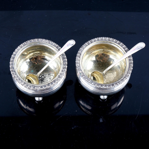 779 - A pair of George III silver salt cellars, bulbous circular form with gadrooned rim, bun feet and gil... 