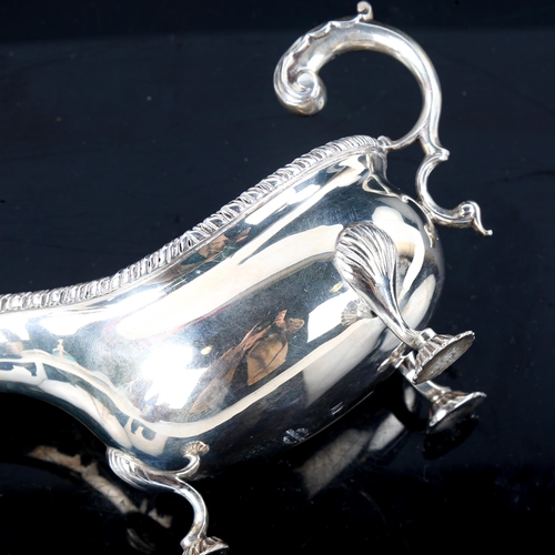 780 - An Edwardian silver sauce boat, gadrooned rim with shell feet and scrolled C-shape acanthus leaf han... 