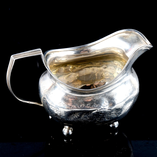 789 - A George III silver cream jug, bright-cut engraved floral decoration with gilt interior and bun feet... 