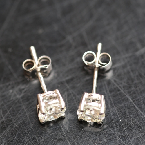 679 - A pair of modern 1.2ct solitaire diamond stud earrings, in 18ct white gold settings with modern roun... 